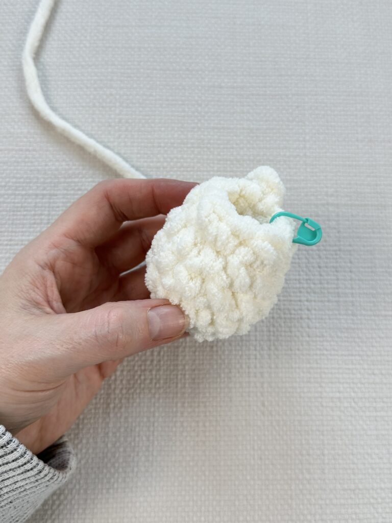 Hands showing a crochet egg ready to be stuffed. 