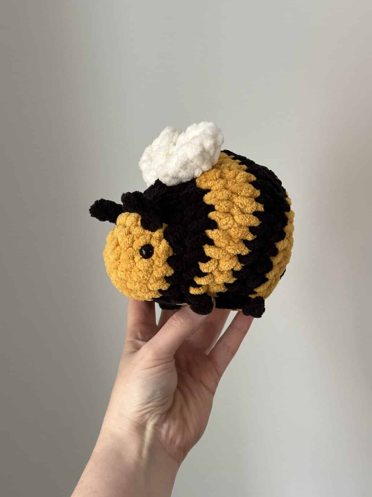 Hand holding a cute crochet bumblebee.