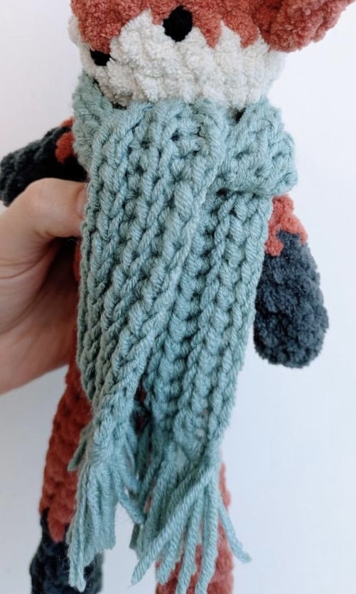 Crocheted fox with cozy blue fable scarf.