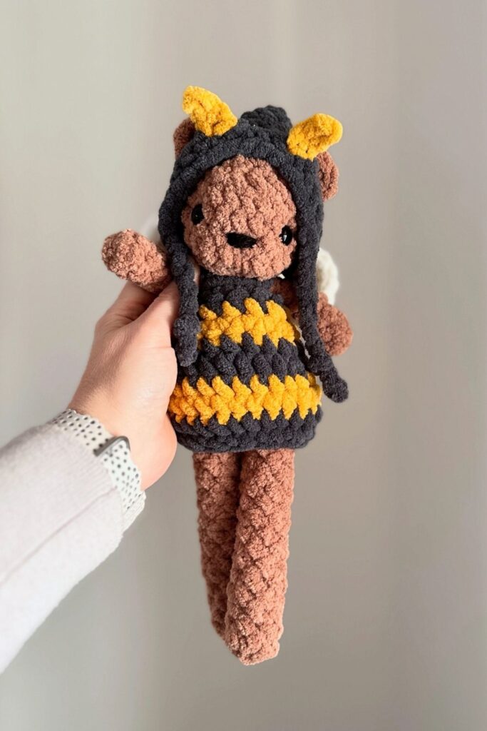 Crocheted bear wearing bee outfit.