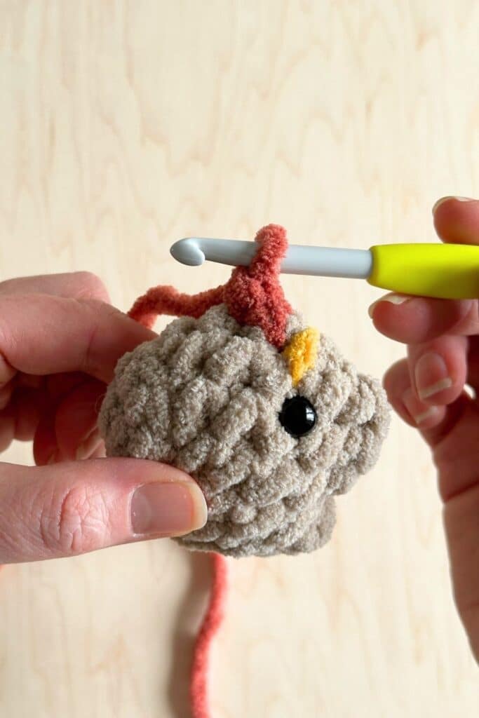 The second crochet stitch to make a rooster's under beak.