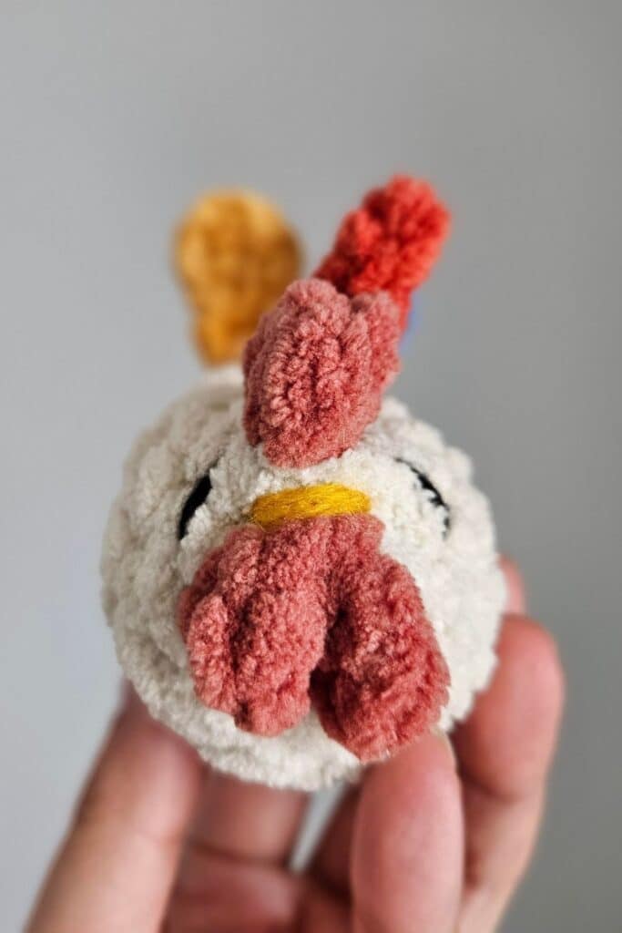 Front view of a small crocheted rooster.