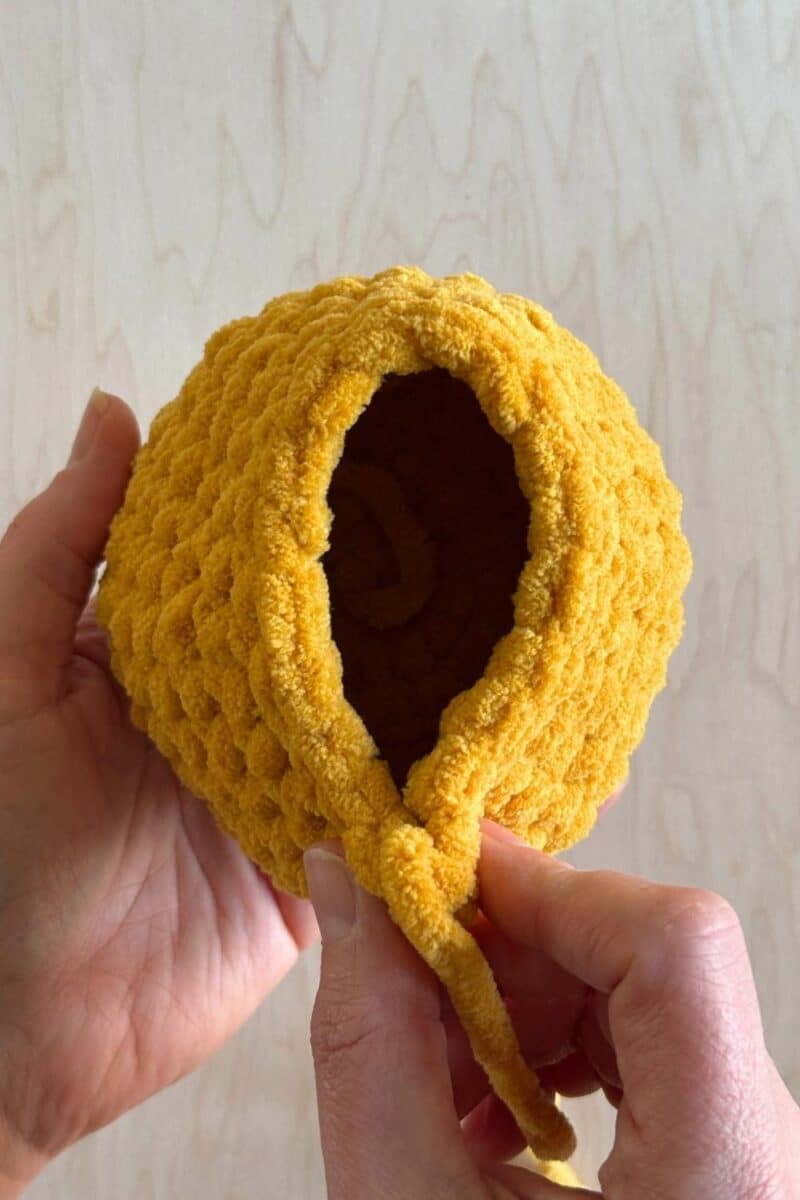 A process photo of a yellow crochet duck.
