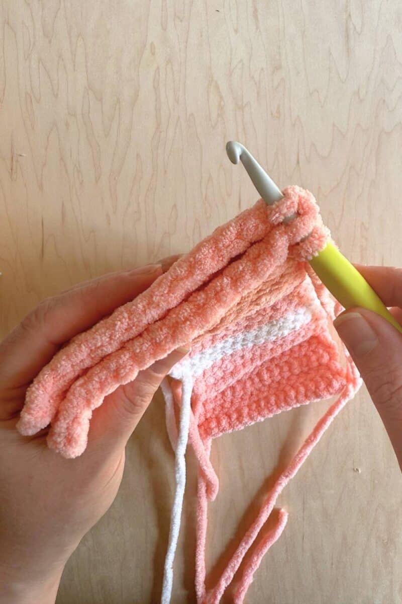 Process photo showing inserting your hook into the front and back layers of the sleeping bag. 