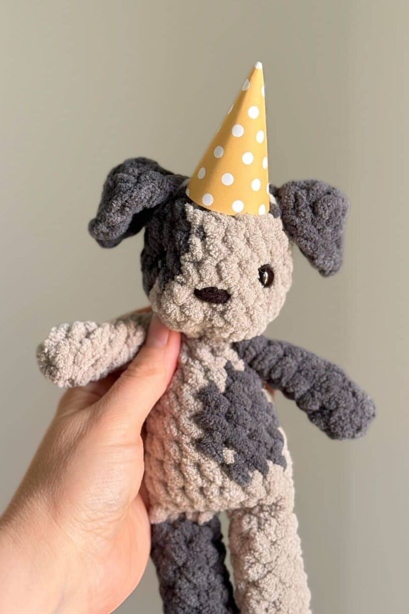 Marley the crochet dog wearing the party hat. 