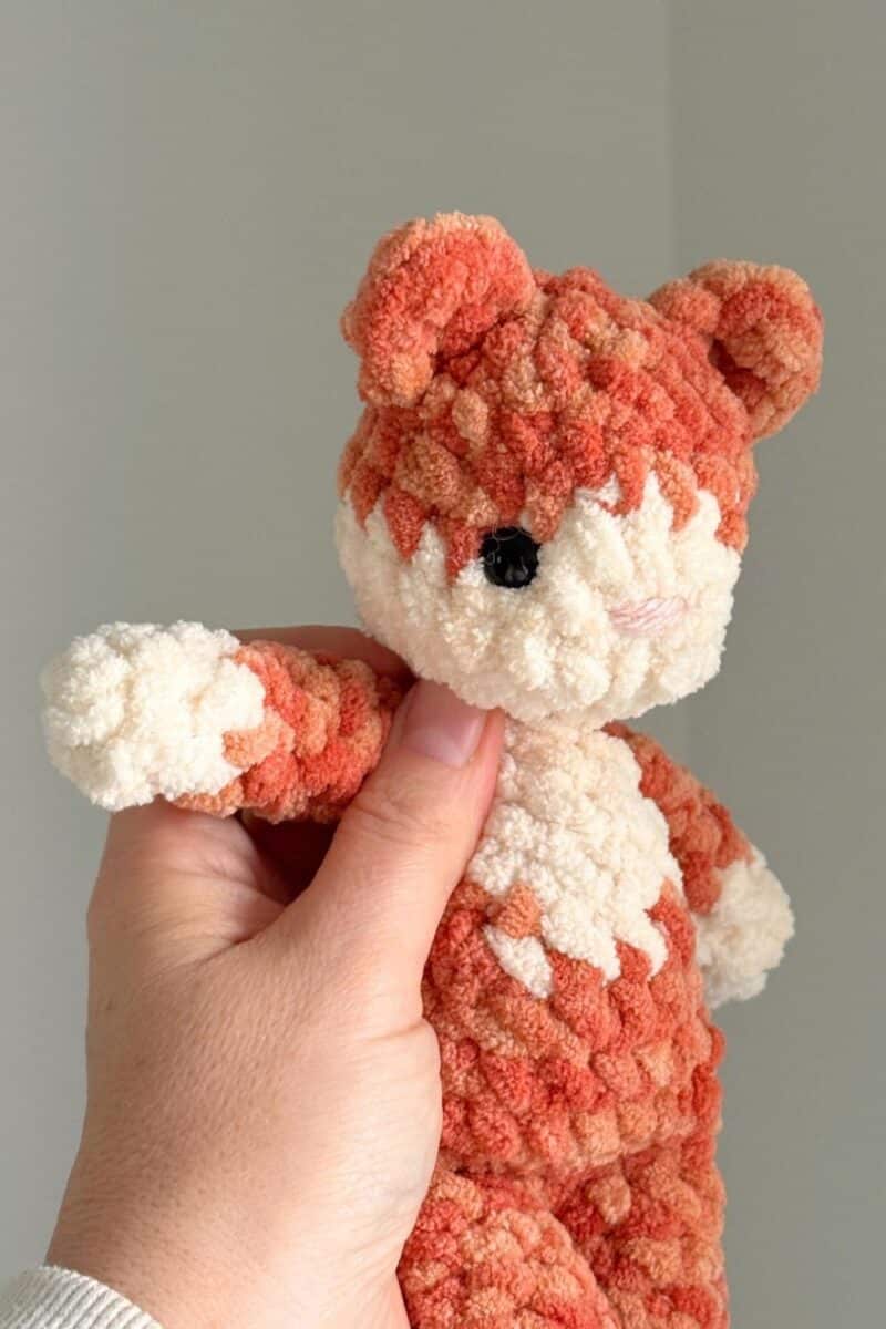 Close up photo of on orange crochet cat with smaller eyes.