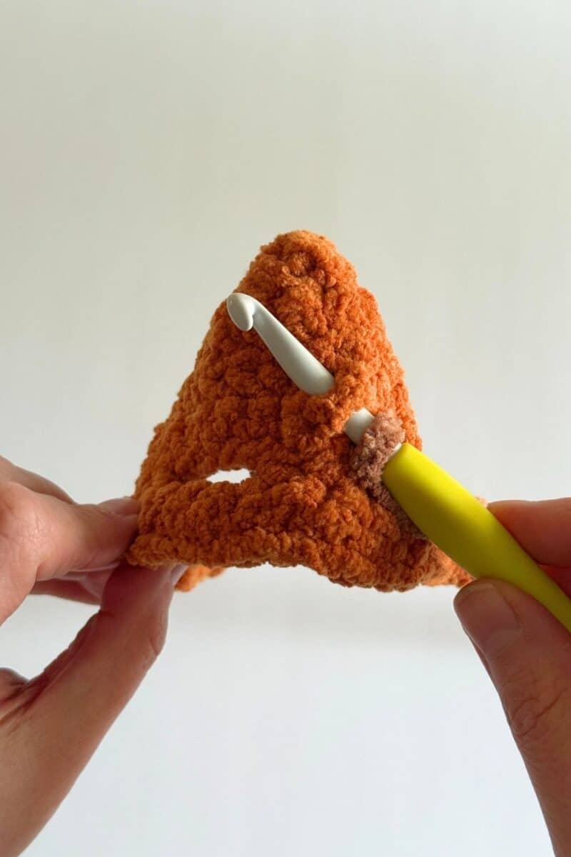 Pricess photo showing where to insert your hook to start adding the stem to the crochet hat.