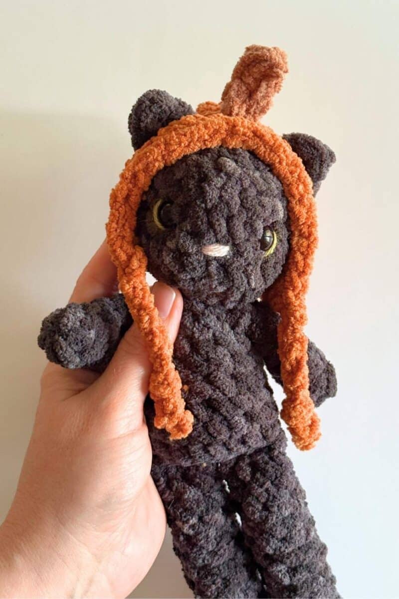 Photo showing the crochet Tilly Cat wearing the pumpkin hat.