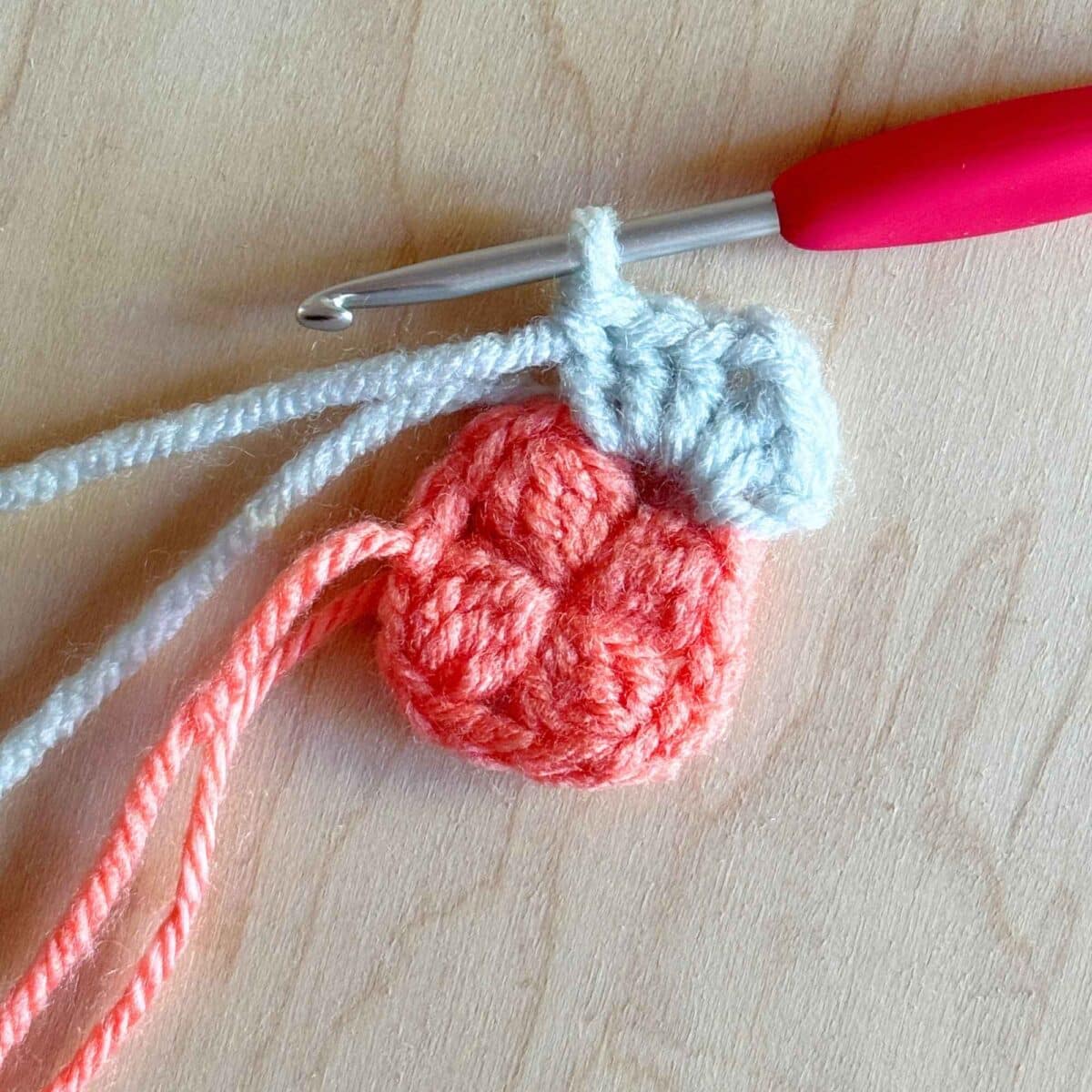 Next step (shown in blue yarn) of making round 2 of the crochet square.