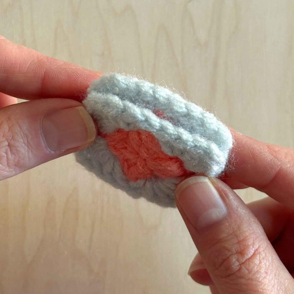 Hands showing both sides of the squares together.