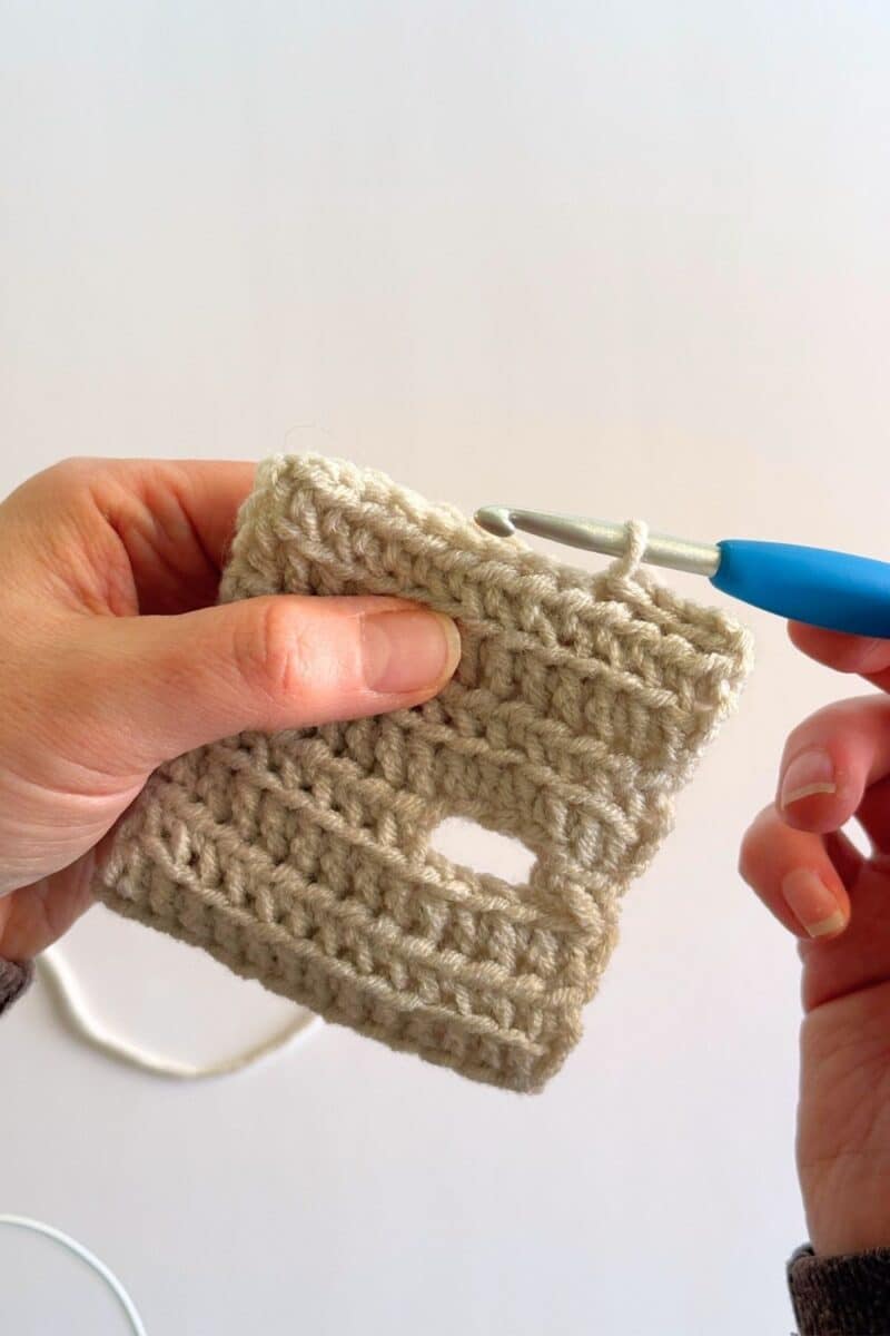 Process photo showing crocheting the hat closed.