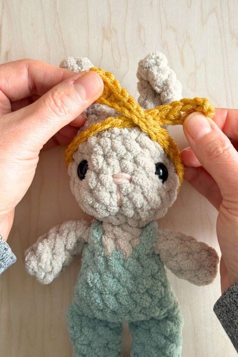 First steps of tying the headband in a knot onto the head.