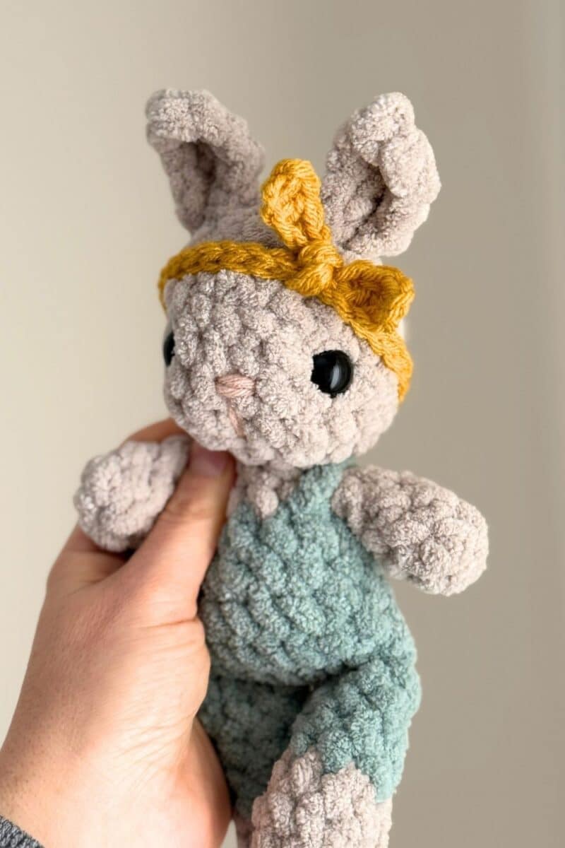 A tiny crochet bunny wearing a crochet headband. 