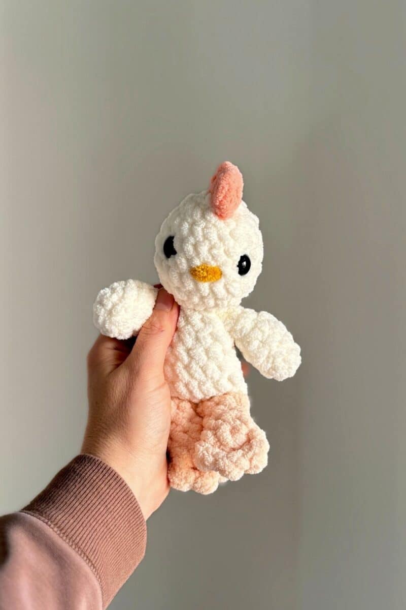 Hand holding a crochet baby chicken.
