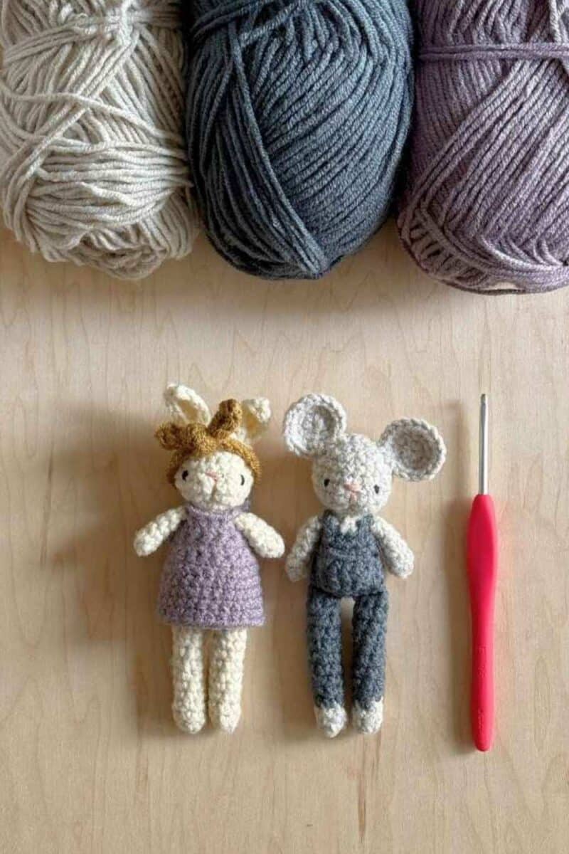 Two tiny crocheted animals - a bunny in a dress and a mouse in overalls.