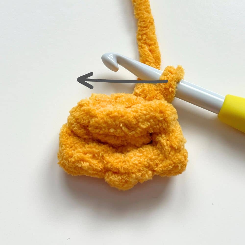 Arrow showing what direction to crochet across the foot.