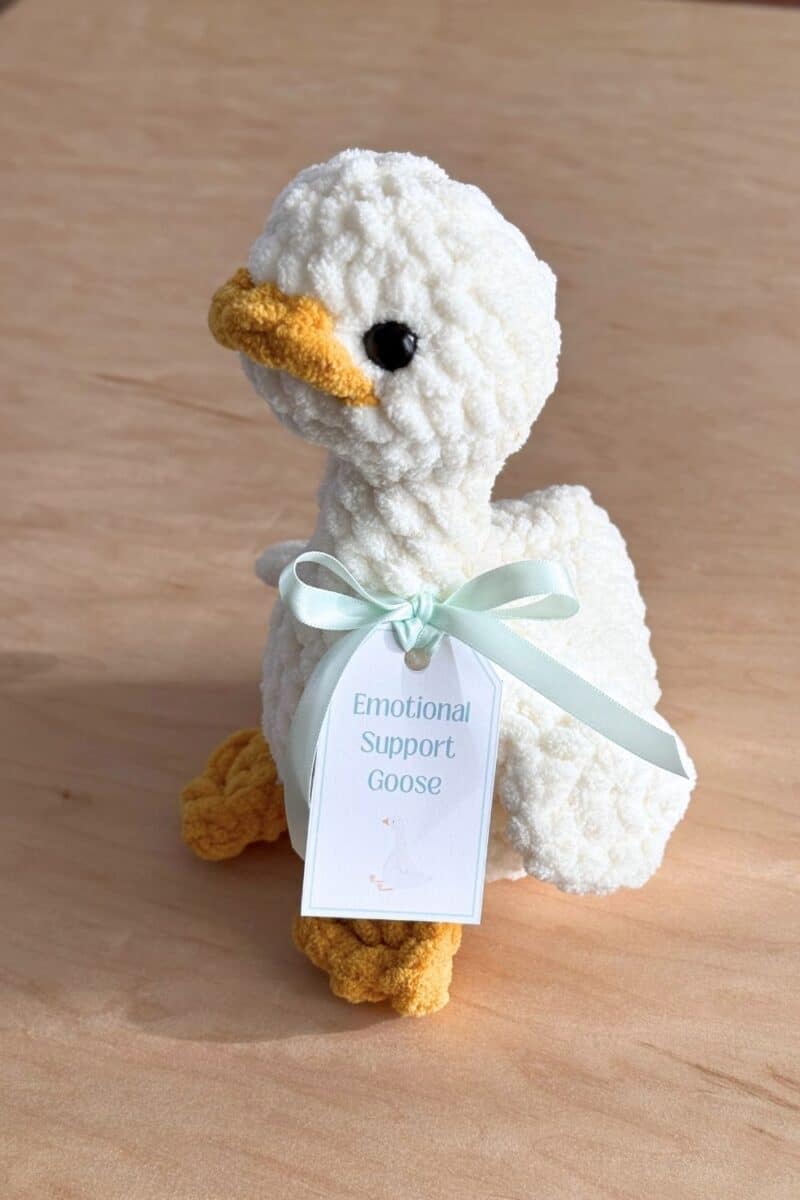 Photo of a crochet goose with an emotional support goose tag attached.