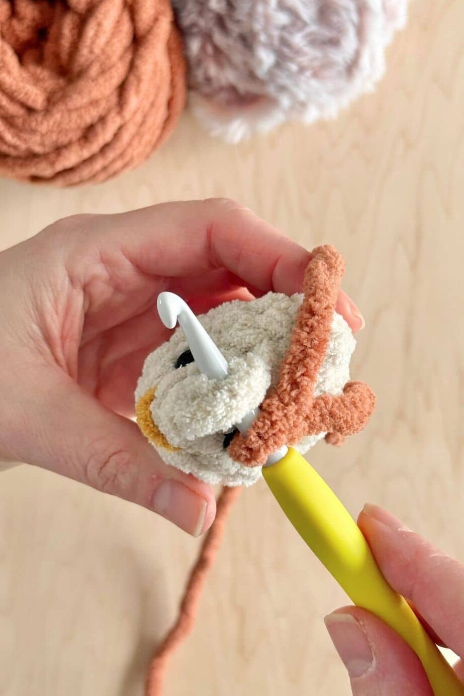 Process photo showing how to add the first stitch to add the comb to the chicken.