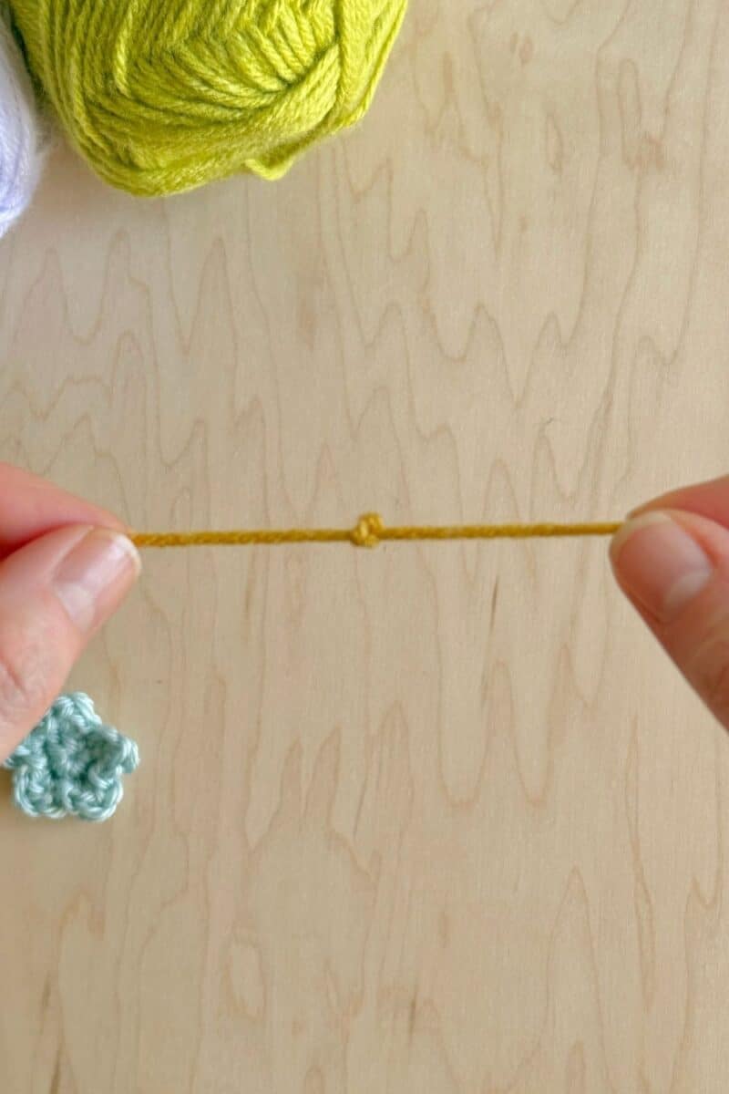 A knot tied in a strand of yarn to make the crochet flower center.