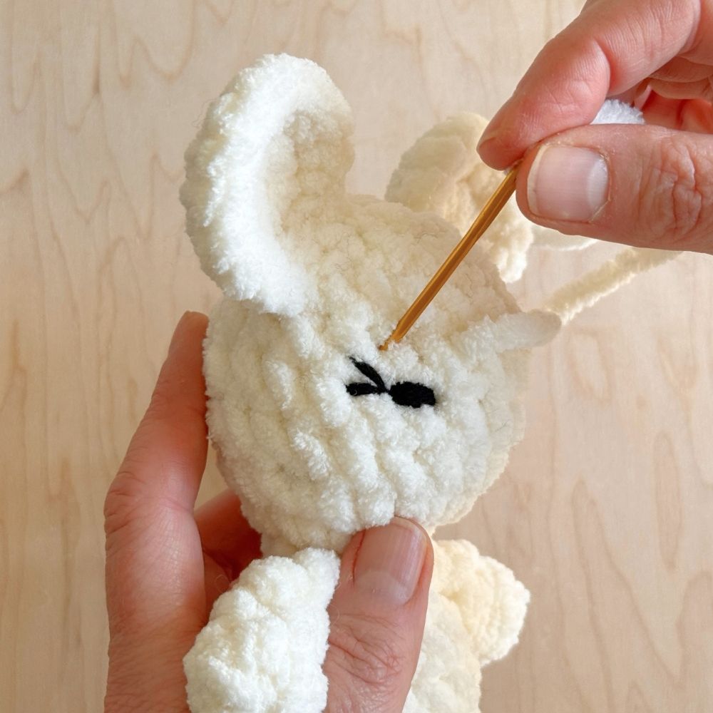 Second steps for shaping the eyes on a crochet mouse.