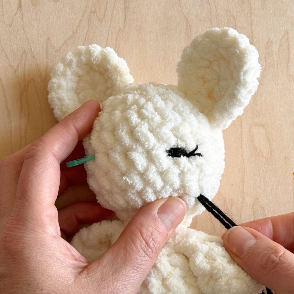 Finished eye and eyelashes on a crochet mouse.