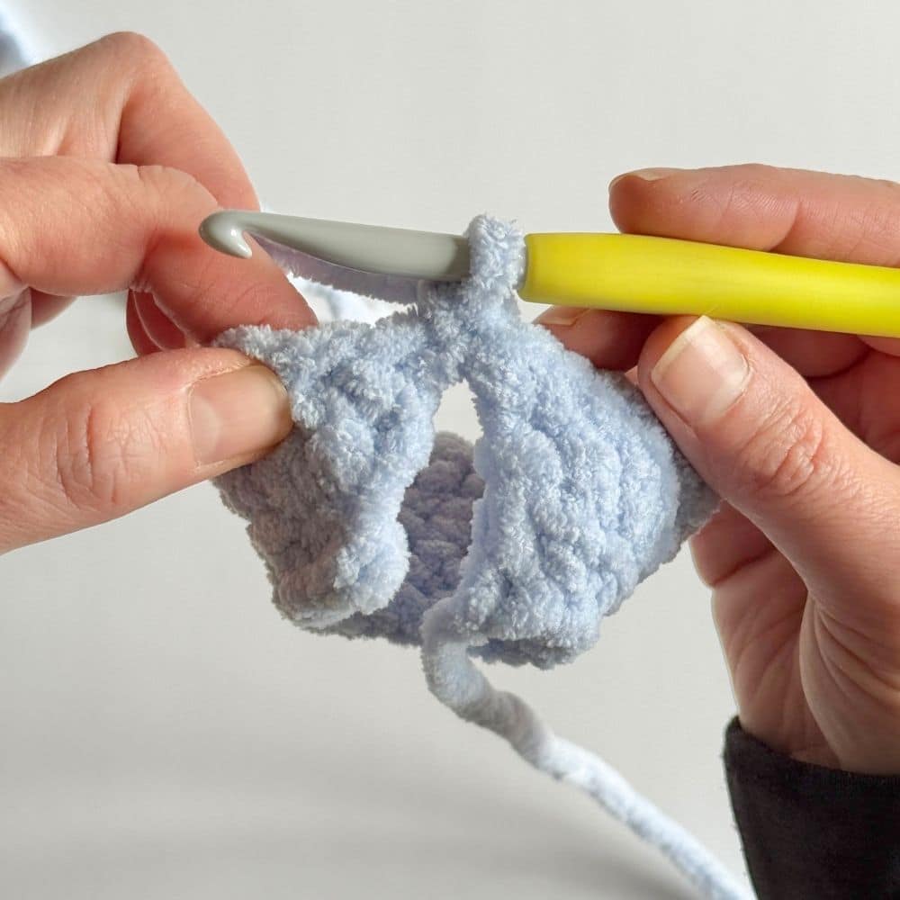 Closing up the back of the blue crochet dress.