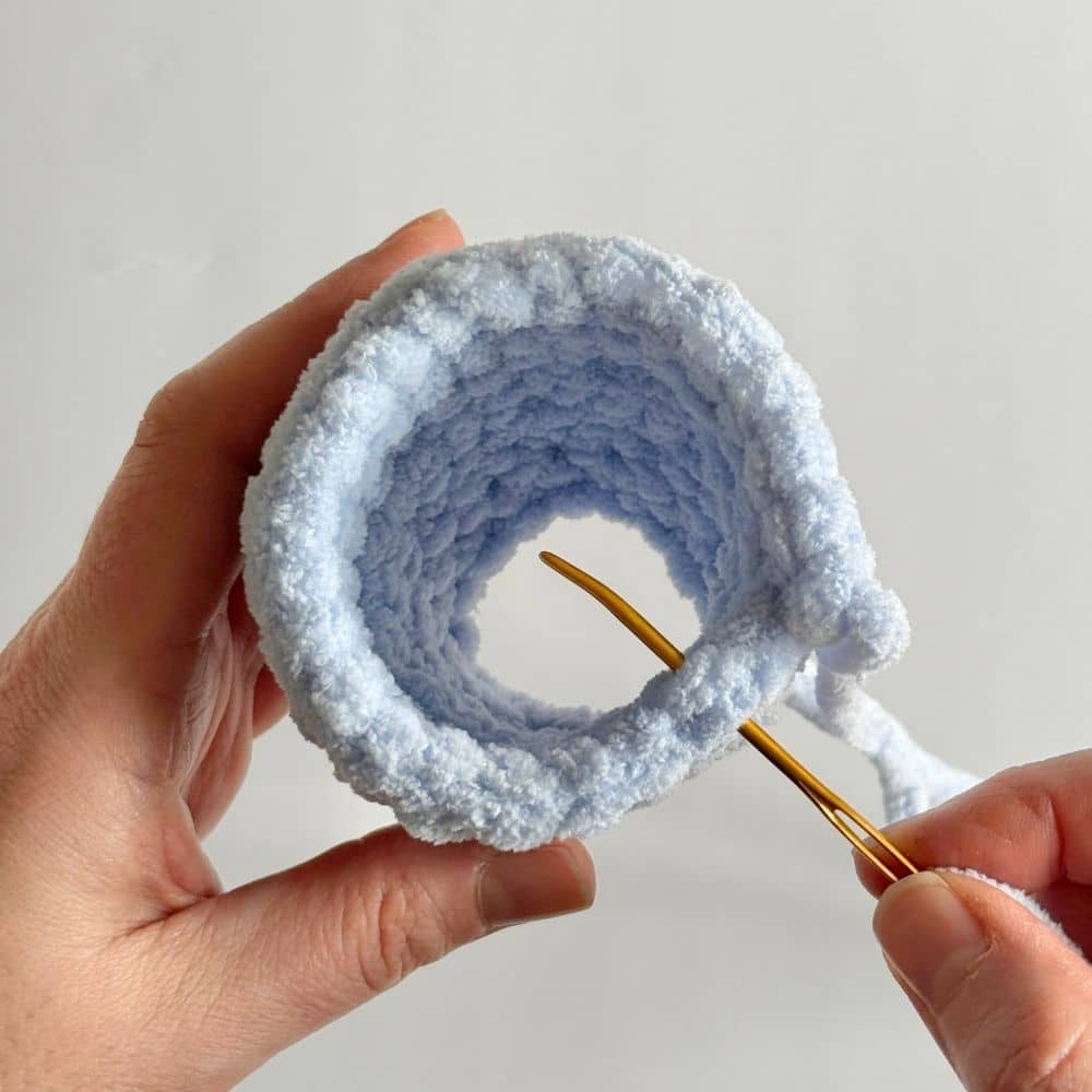 Process photo showing how to complete an invisible finish step on a crochet piece.