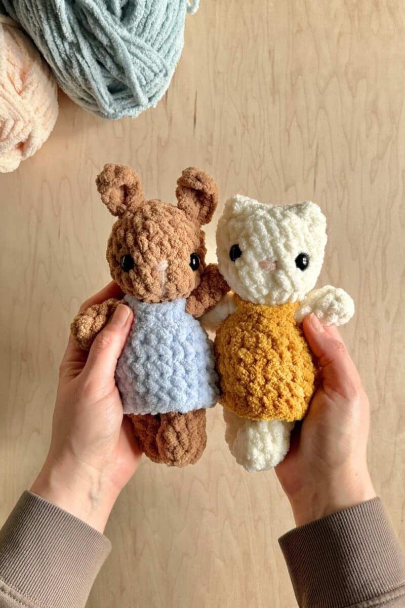 Two crochet animals wearing little dresses.
