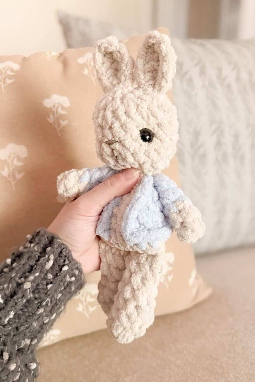 Hand holding a crochet garden bunny.