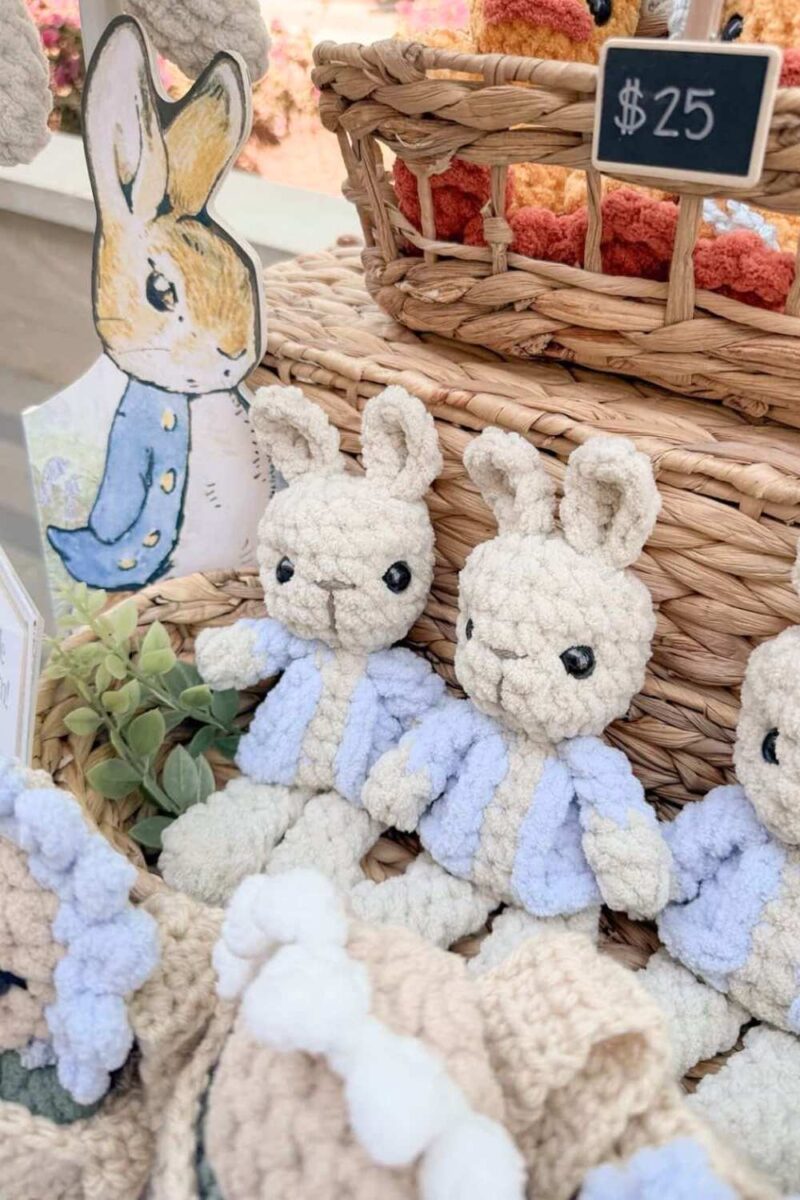 Crochet Peter Rabbit bunnies set up at a market.