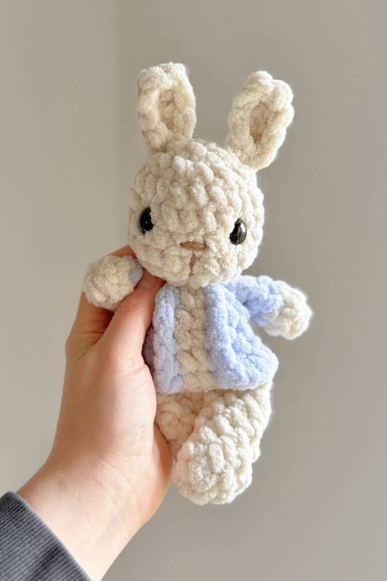 Hand holding a crochet Peter Rabbit plushy.