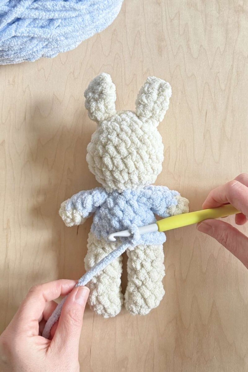 Process photo of adding top stitching along the bottom to a jacket on a Peter Rabbit bunny.