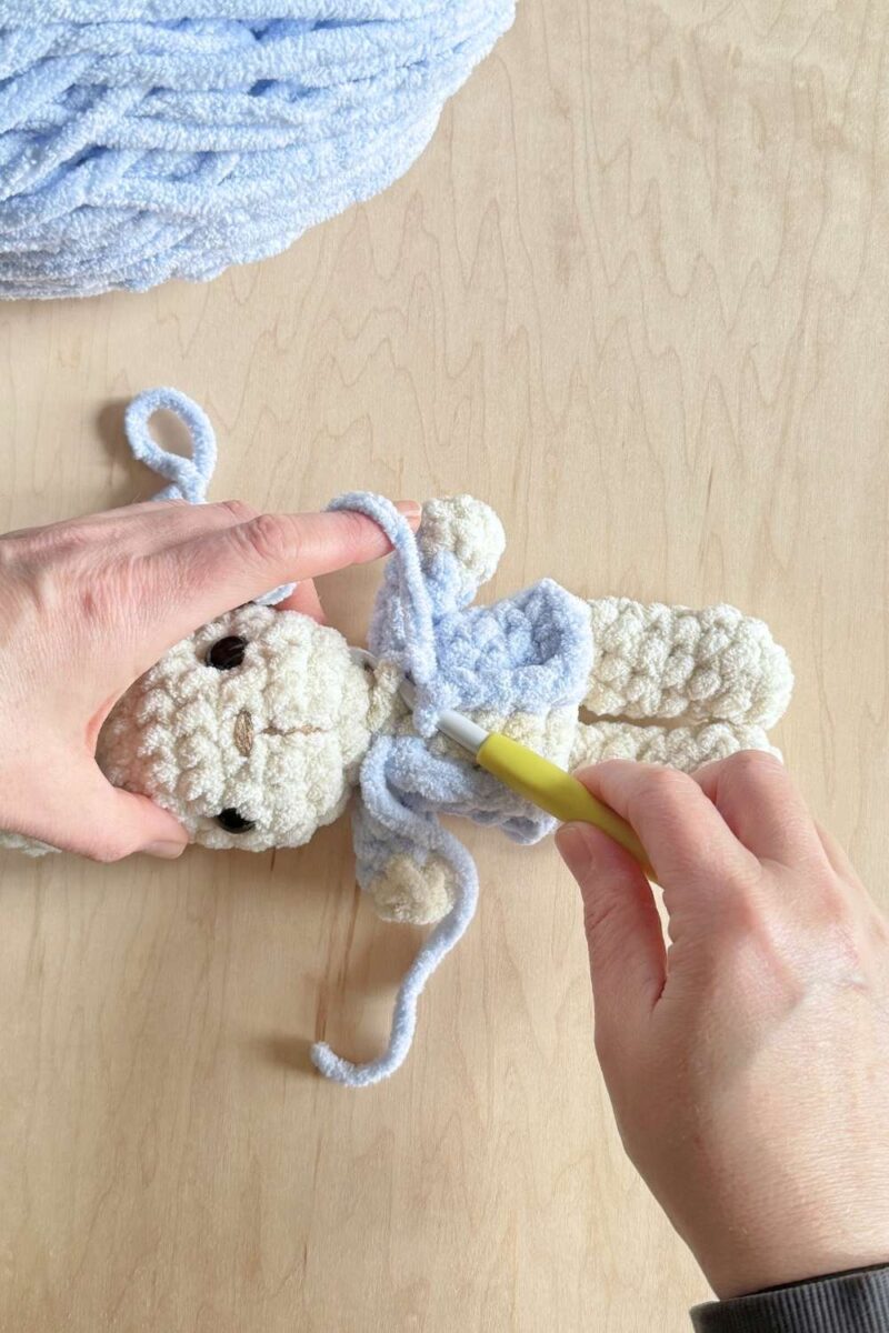 Process photo of adding the final top stitch to a jacket on a Peter Rabbit bunny.