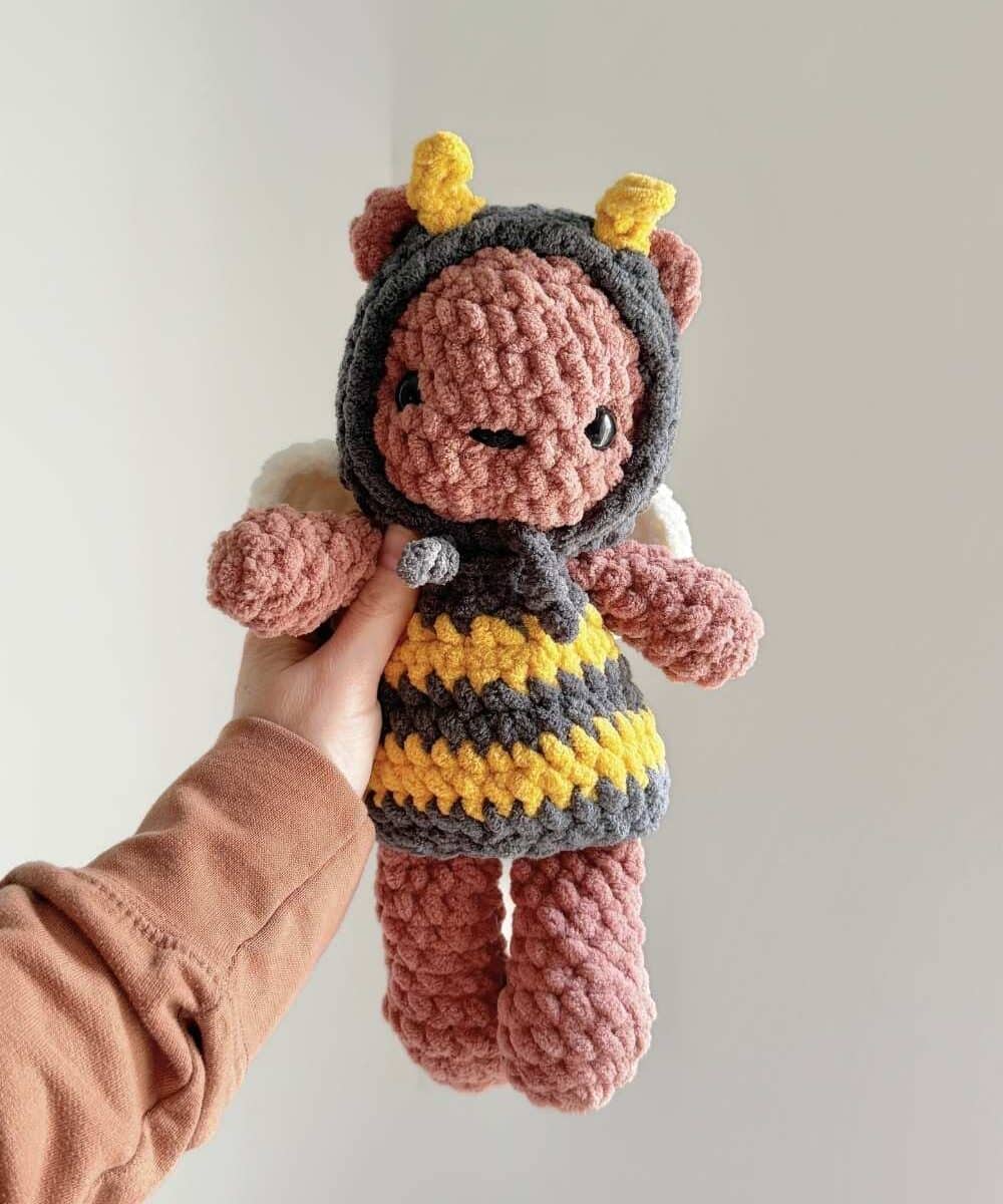 A large crochet bear wearing a removable bee costume.