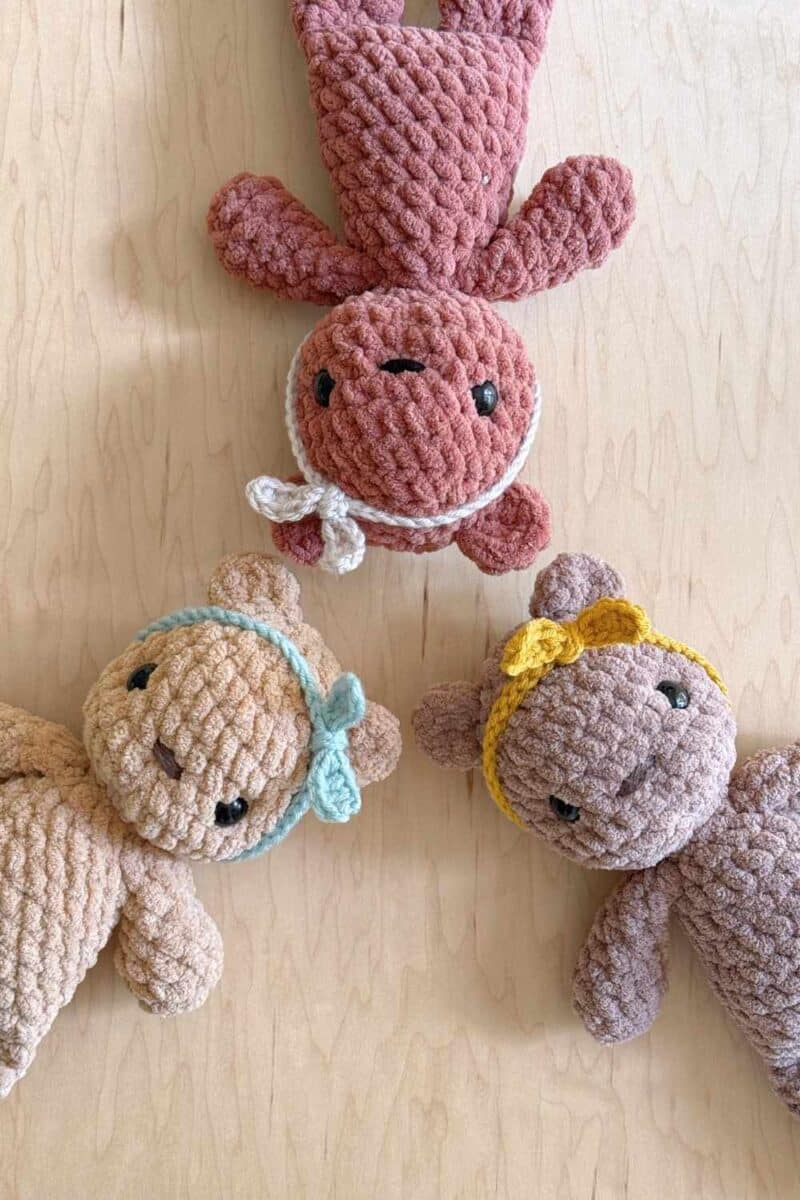 Three crochet bears with heads together wearing different colored crochet headbands.