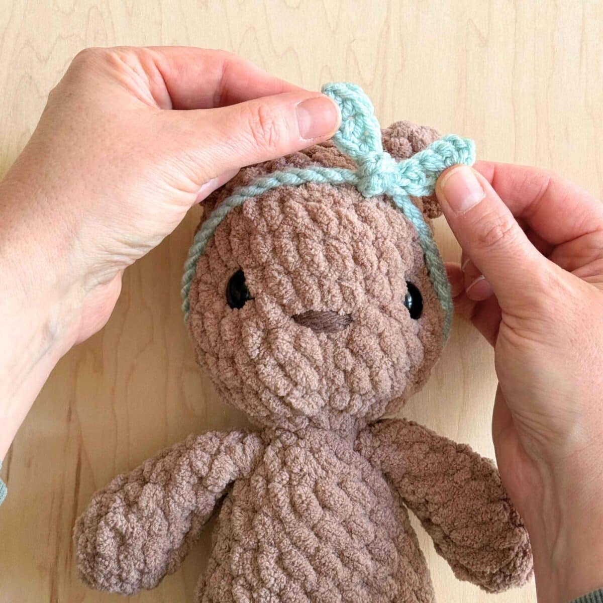 Crochet headband knotted onto the bear's head.