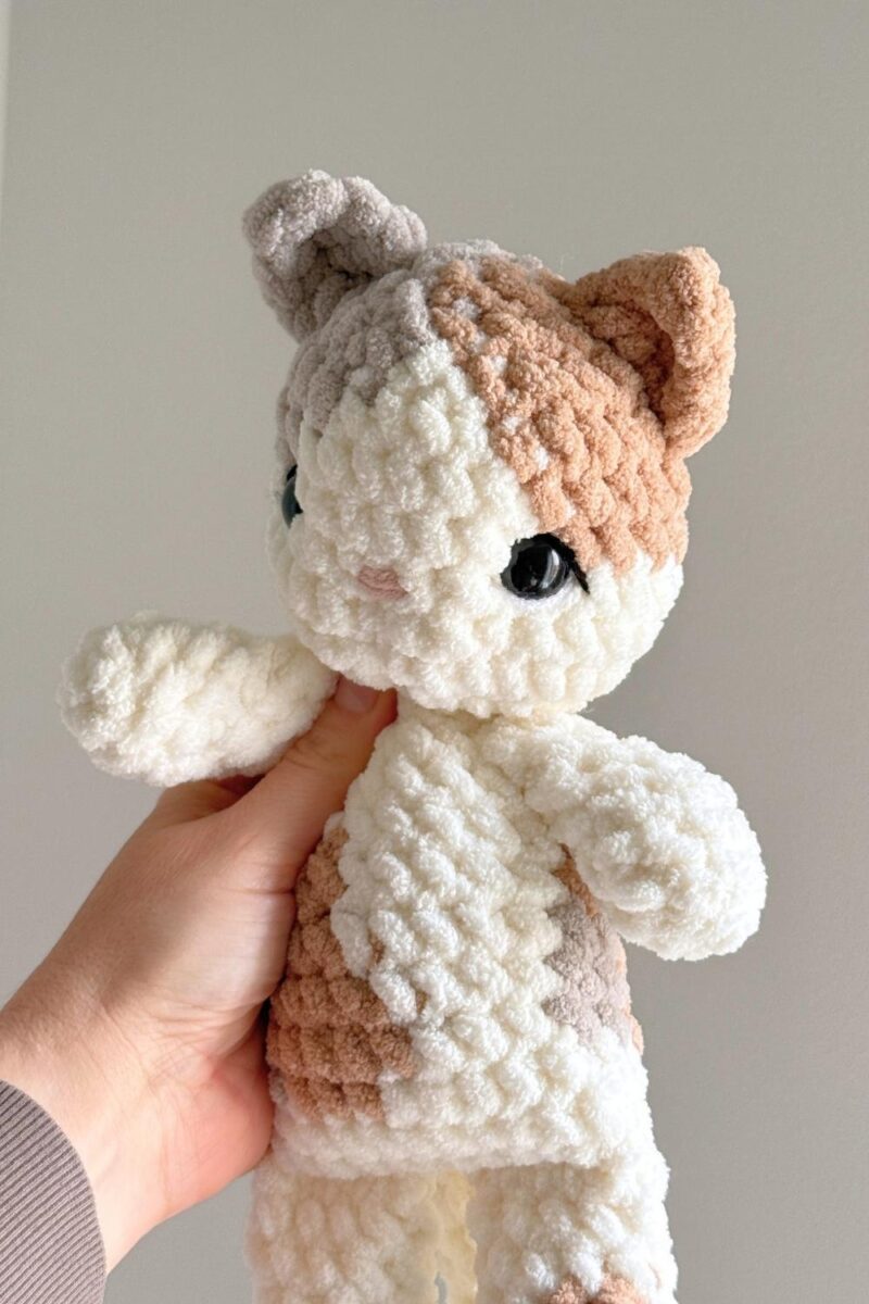 A close up photo of a crochet kitty showing eye detailing.