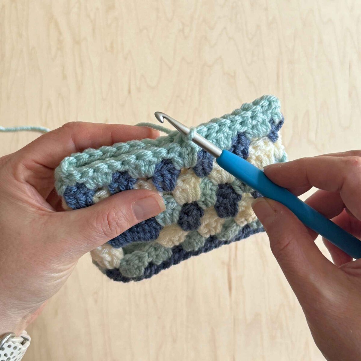 A process photo showing closing the back of the hat with slip stitches