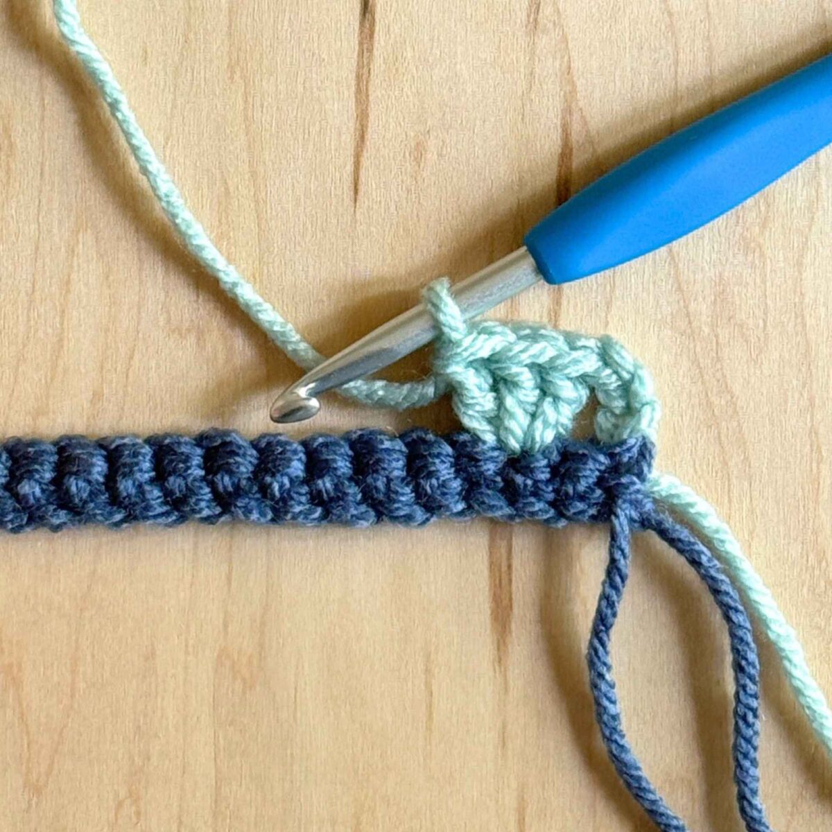 Process photo showing how to complete the second step of row 2 of the hat.