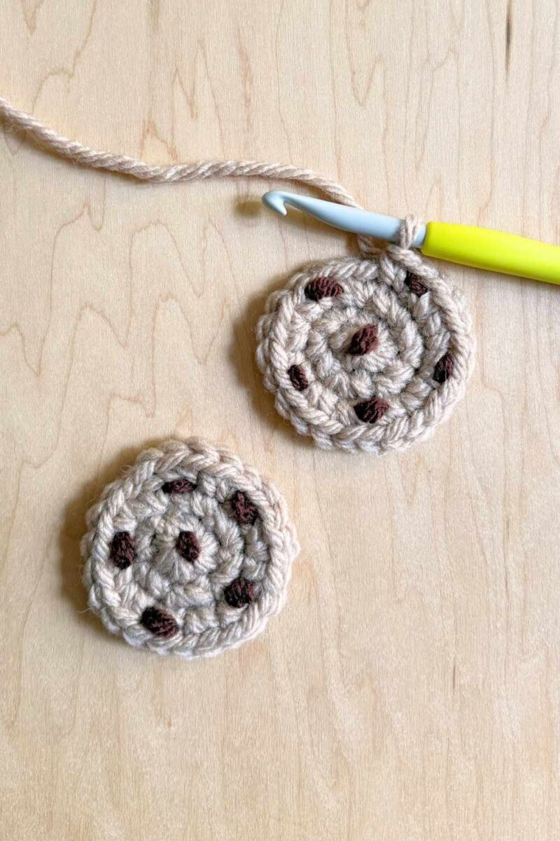 A process photo of two crochet cookies with embroidered chocolate chips.