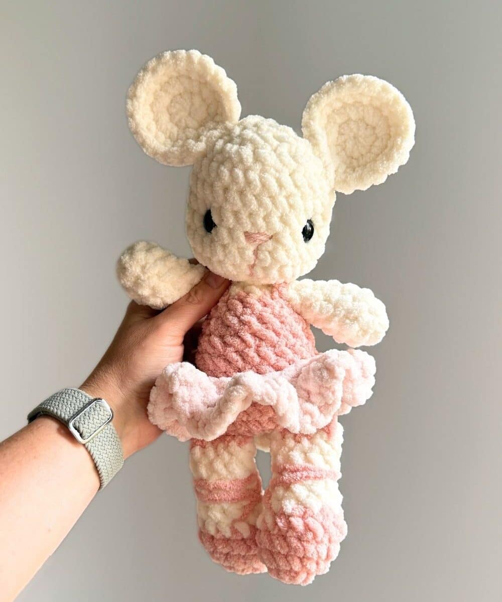 A pink and white crochet ballet mouse.