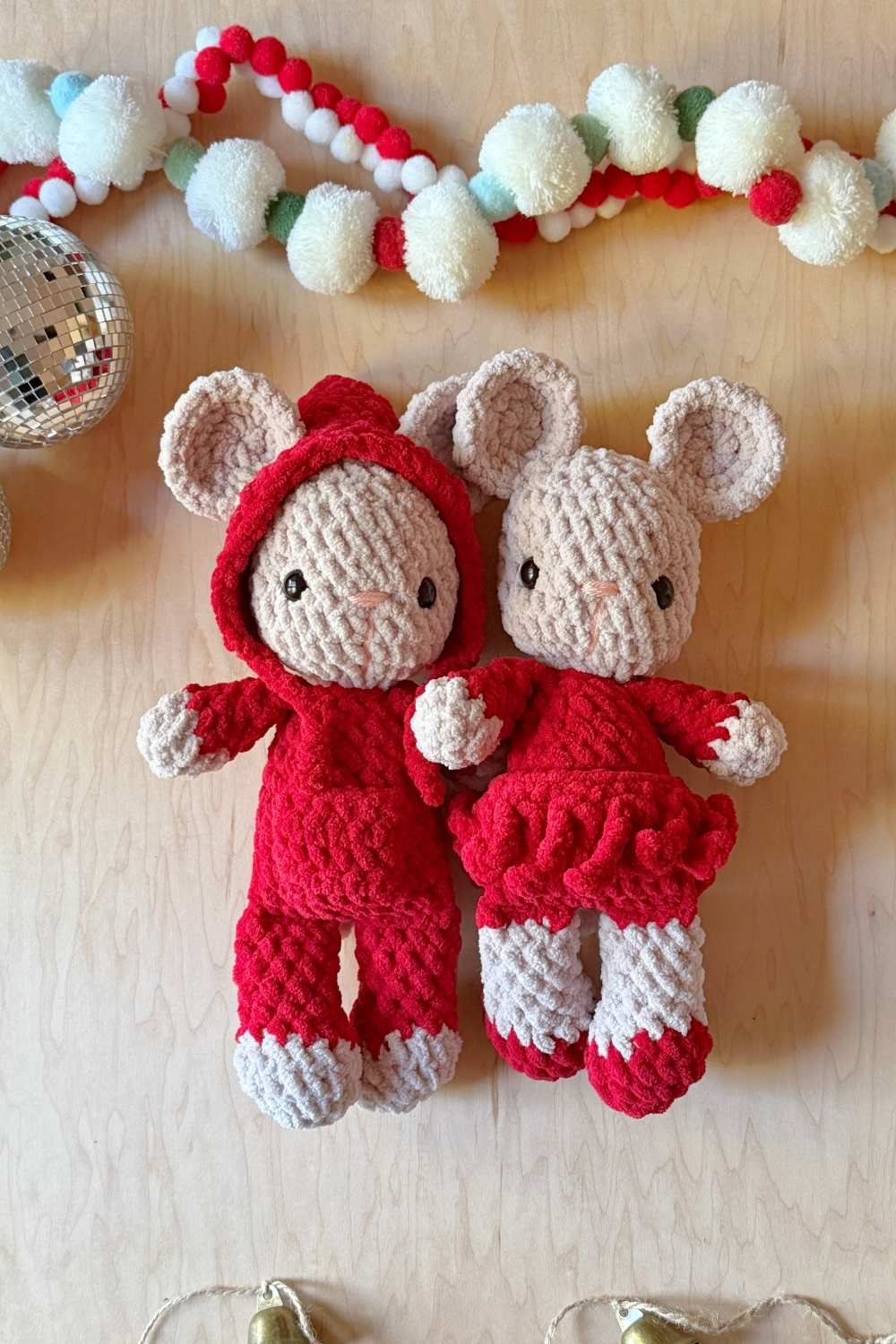 Two crochet Christmas mice with Christmas decor around them.