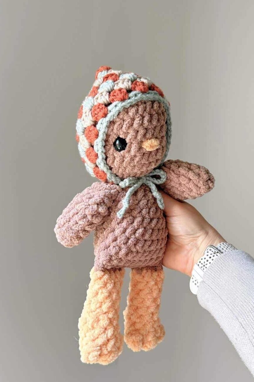 A crochet chicken wearing a crochet hat.