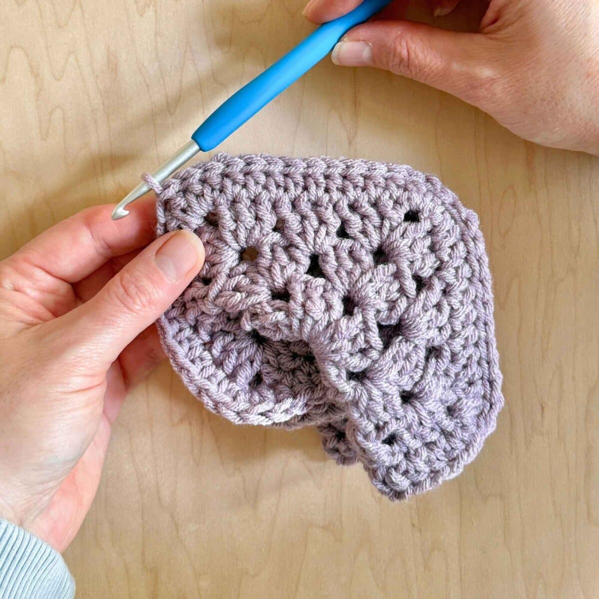 Showing final stitches closing the sweater.