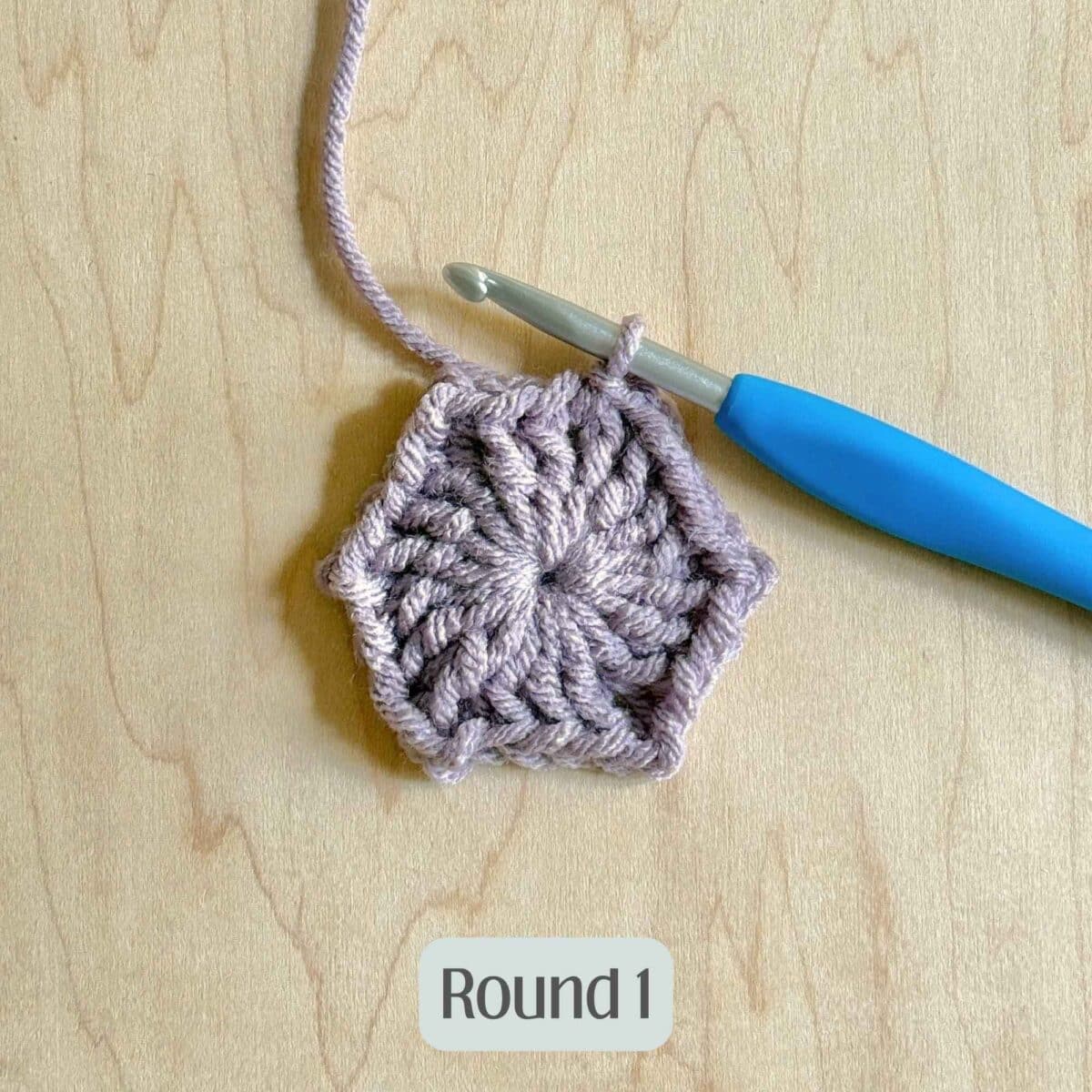 Process photo showing round 1 of the purple crochet hexagon.