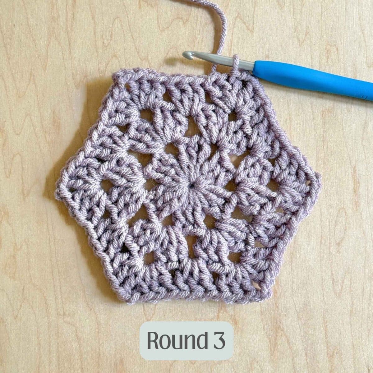 Process photo showing round 3 of the purple crochet hexagon.