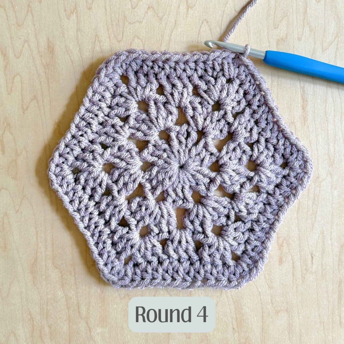 Process photo showing round 4 of the purple crochet hexagon.